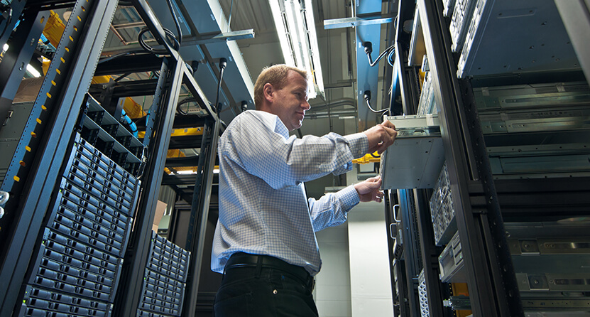 An Opus Interactive blog post about a Hosting Provider, the image depicts a man working in a server room.