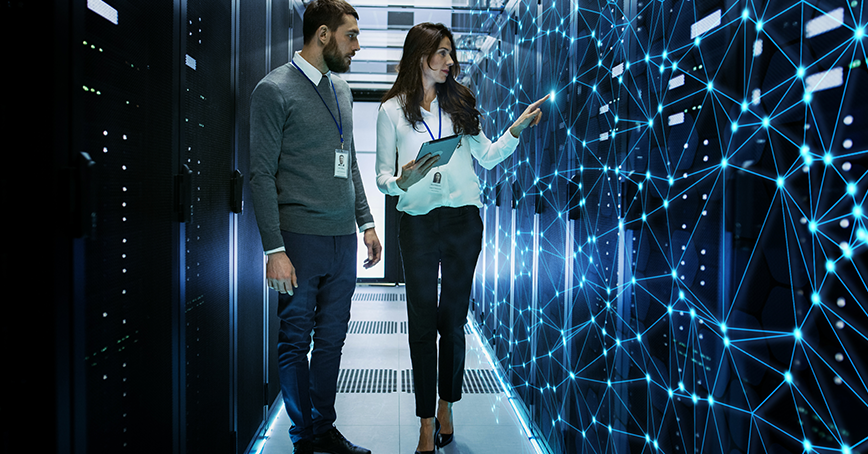 A blog post image that shows two IT technicians in a server room, the woman on the right side has a tablet and is interacting with a web-like interface covering the servers, used to illustrate the inner activity of the servers.