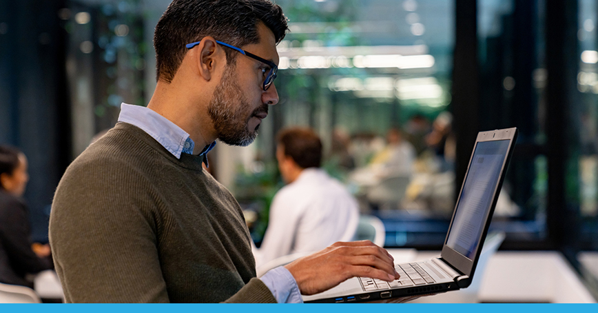 Blog post image of a businessman on a laptop in the office showing how enterprises are using IaaS to stay agile and secure