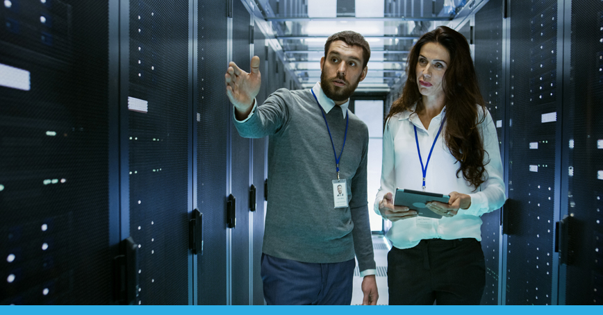 A blog post image featuring a man and woman in a service room, with the man motioning to the woman to look in a certain direction, likely giving instructions on the inner operations of the server room.